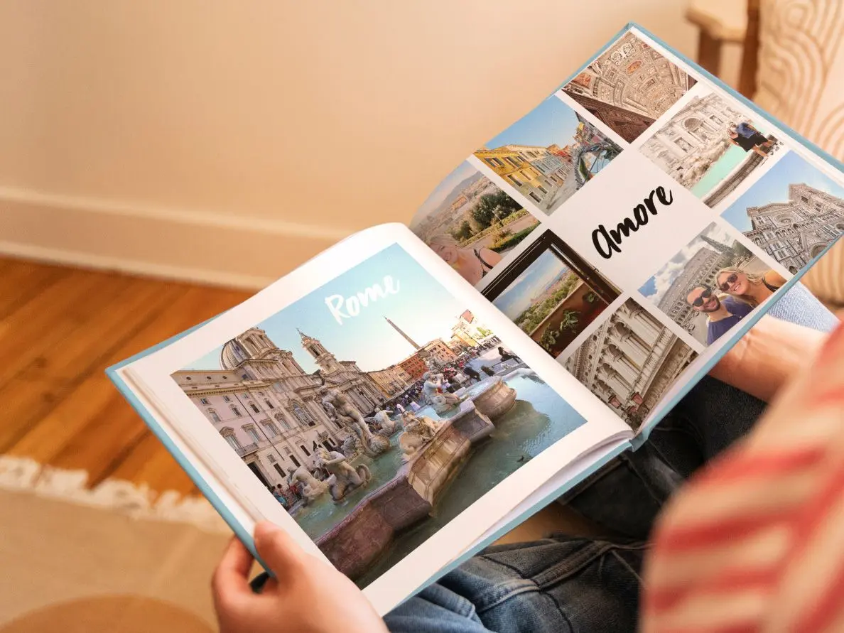 Friends smiling while flipping through a printed photo album