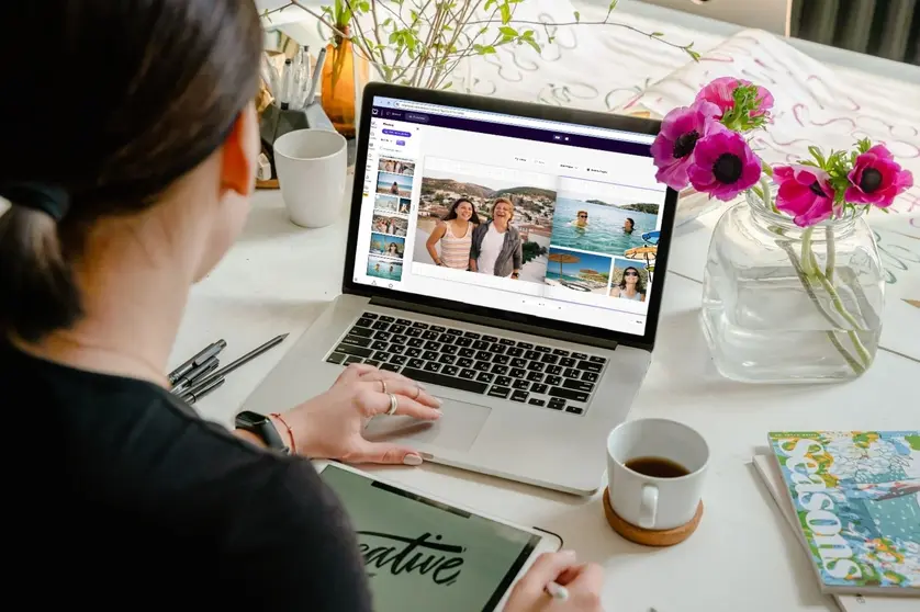 A photo of a woman creating a book on her laptop