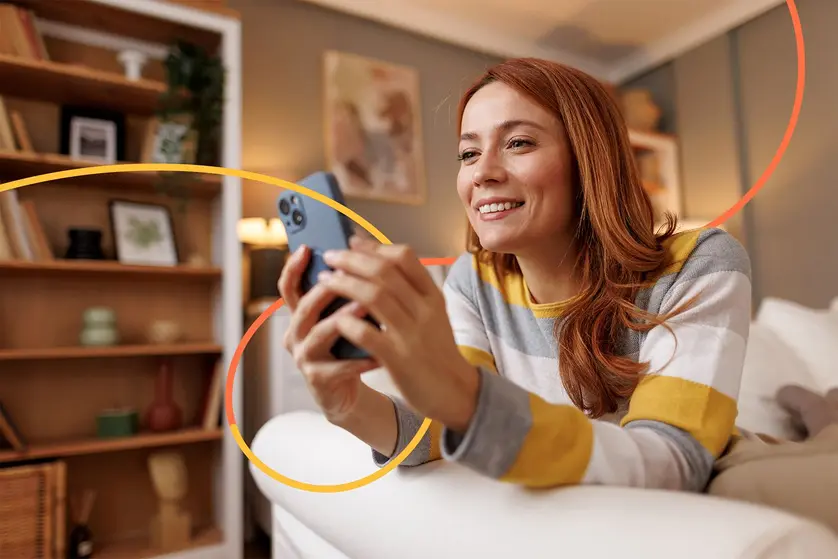 An image of a woman using a smartphone while decluttering and enjoying an organized digital space.