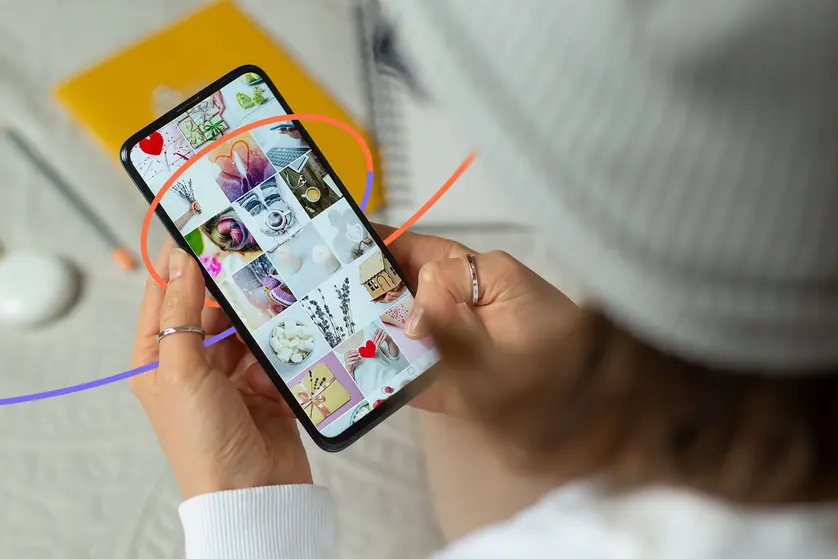 A person scrolls through photos on their phone.