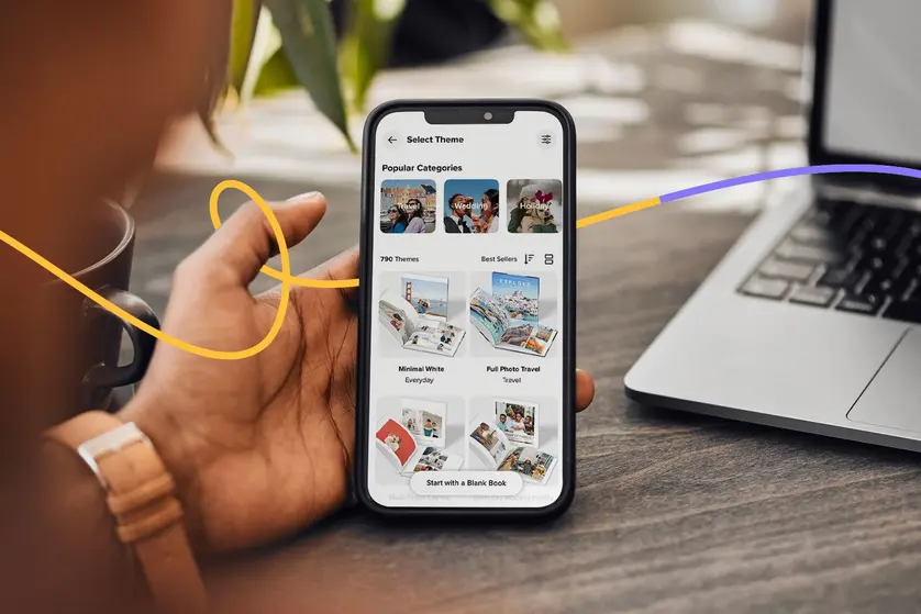 An image of a phone user scrolling through the Mixbook app.
