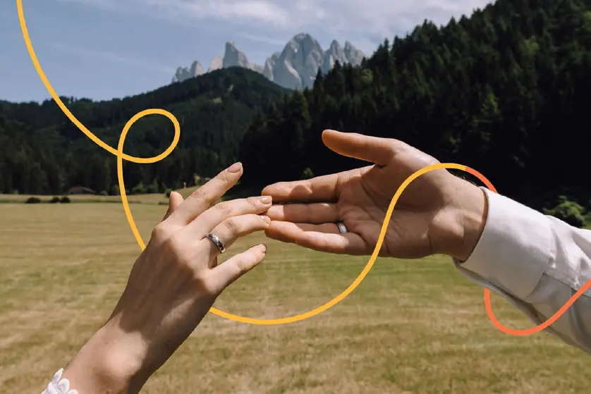An image of two hands wearing rings reaching toward each other.
