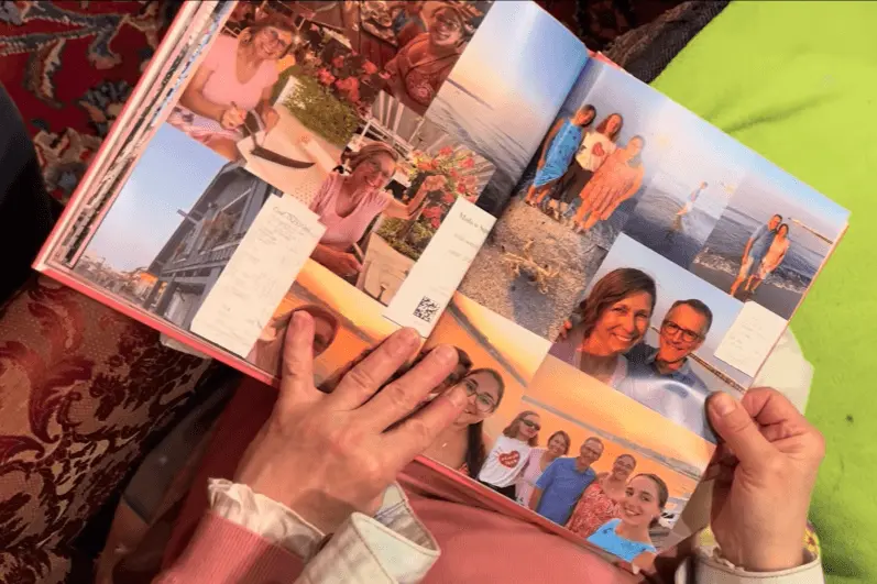 Open photo book showing collage layout of family travel memories and candid moments