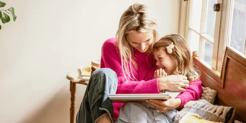  A woman and her daughter enjoying a sentimental moment at home, looking through a photo book together.