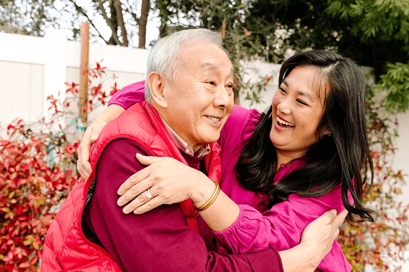 Father and daughter hugging outdoors during the holidays, symbolizing family connection and inspiration for a Mixbook memory book.