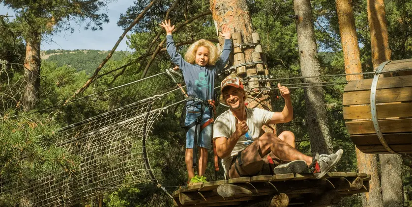 Parent and child enjoying an outdoor adventure course during spring break